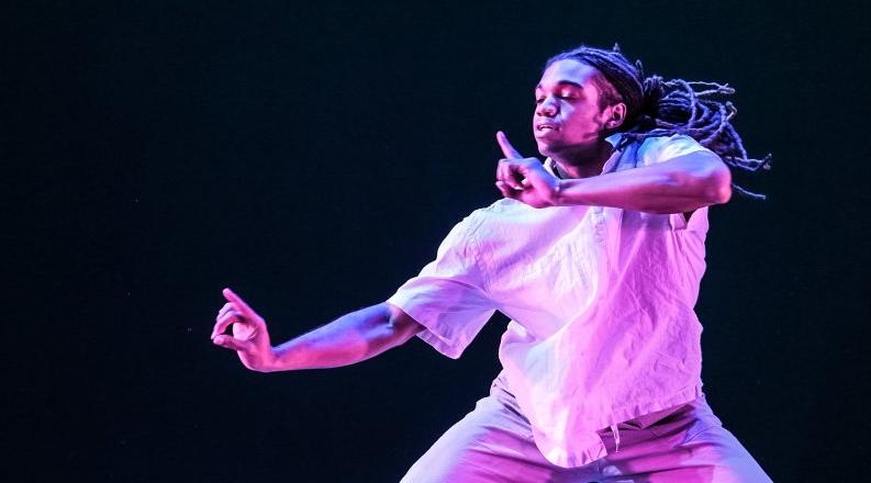 卡梅伦克拉克 gestures with his hands in a moment from a previous performance